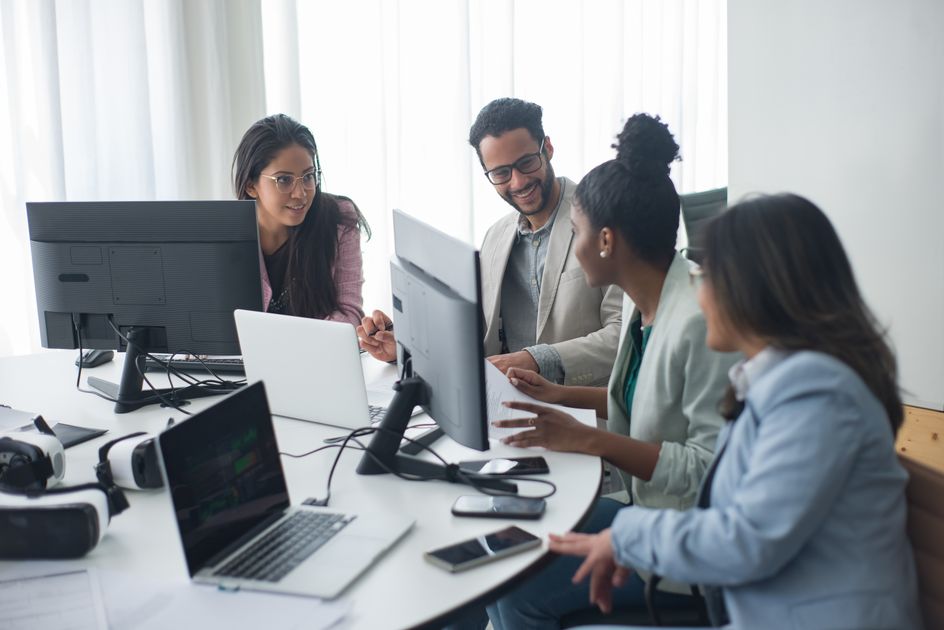 A team discussing work around computers in an office