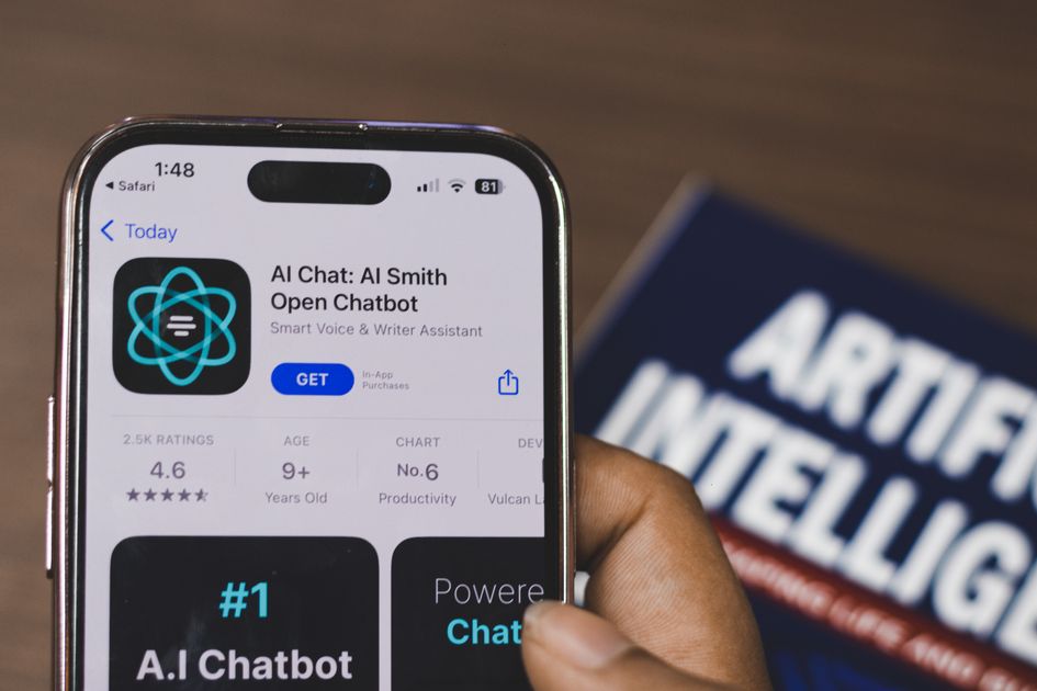 A hand holding a smartphone displaying an AI chat interface
