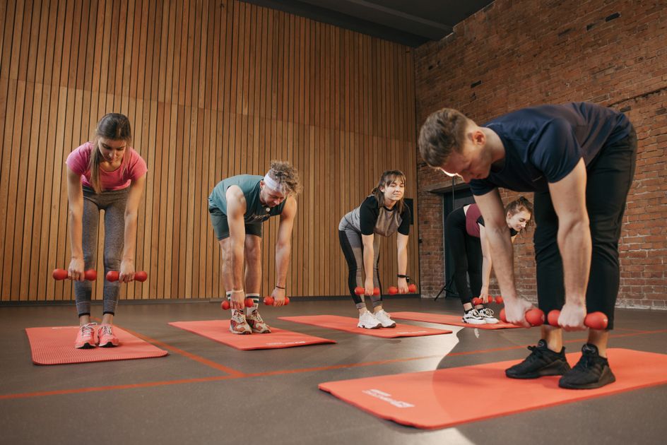 A group performing exercises together in a fitness studio