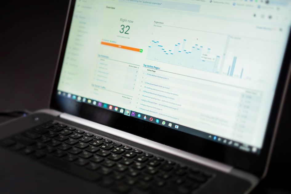 A laptop displaying an analytics dashboard with charts
