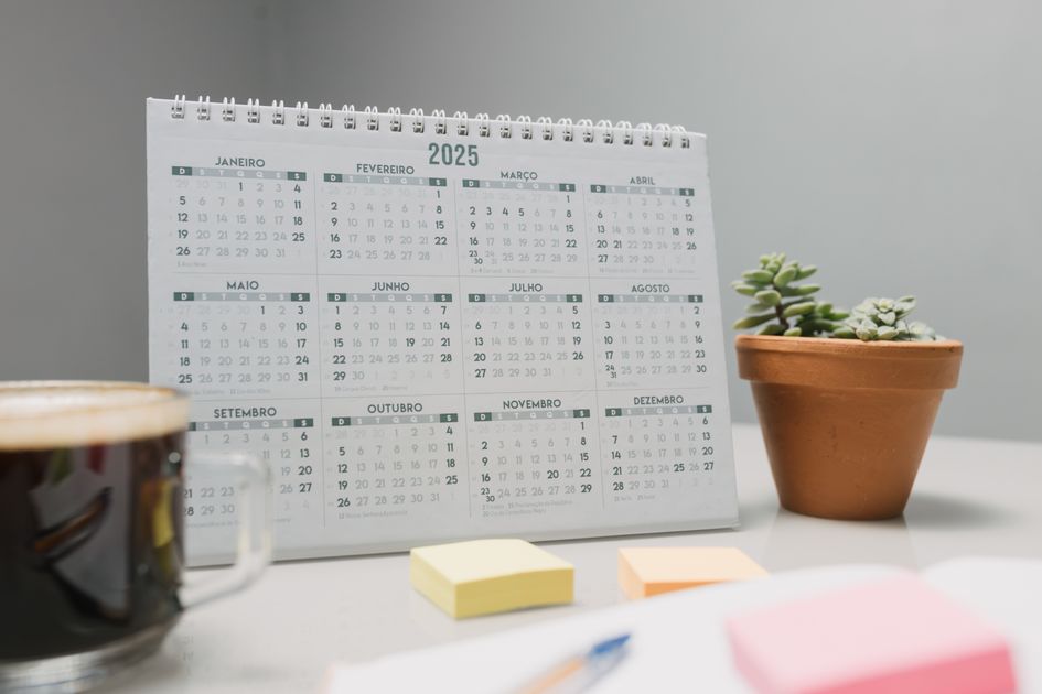 A 2025 desk calendar with coffee and succulents