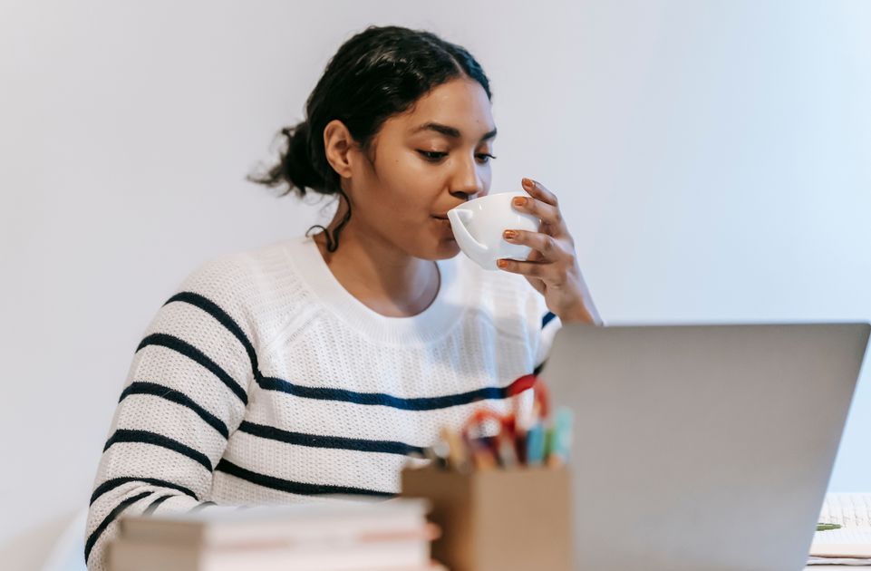 A freelancer working remotely on a laptop with a cup of coffee