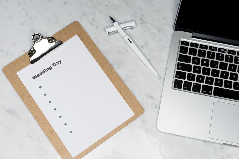 A flat lay of a planning setup with clipboard and laptop