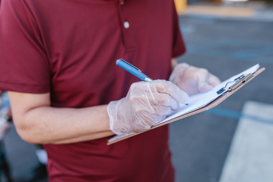 A person writing on a clipboard outdoors