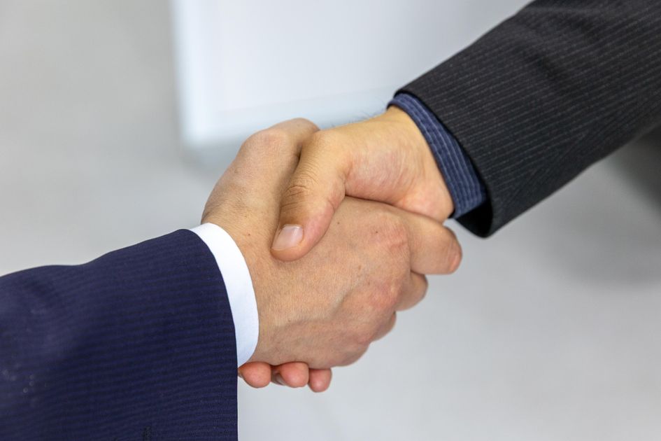 Two businesspeople shaking hands on a new client relationship