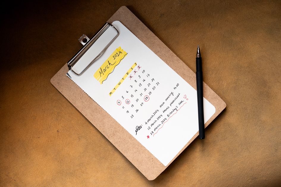 A calendar on a clipboard with a pen