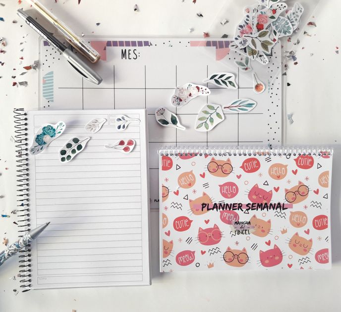 A colorful flat lay of a planner, notebook, and decorative stickers