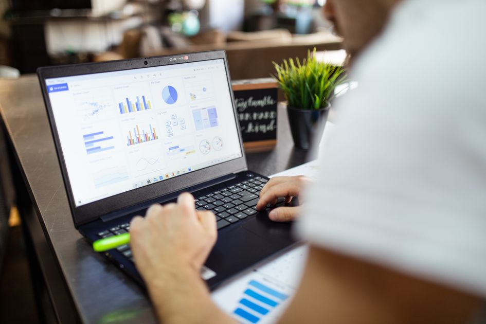 Focused business analysis with charts and graphs on a laptop