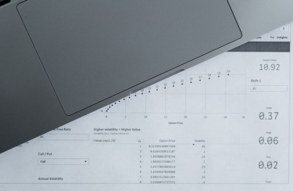 A top-down view of analytical data sheets and a laptop