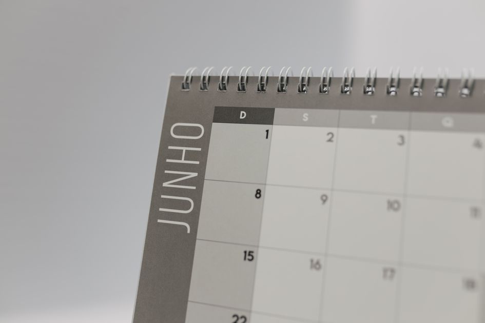 A close-up of a spiral-bound calendar showing a monthly date grid