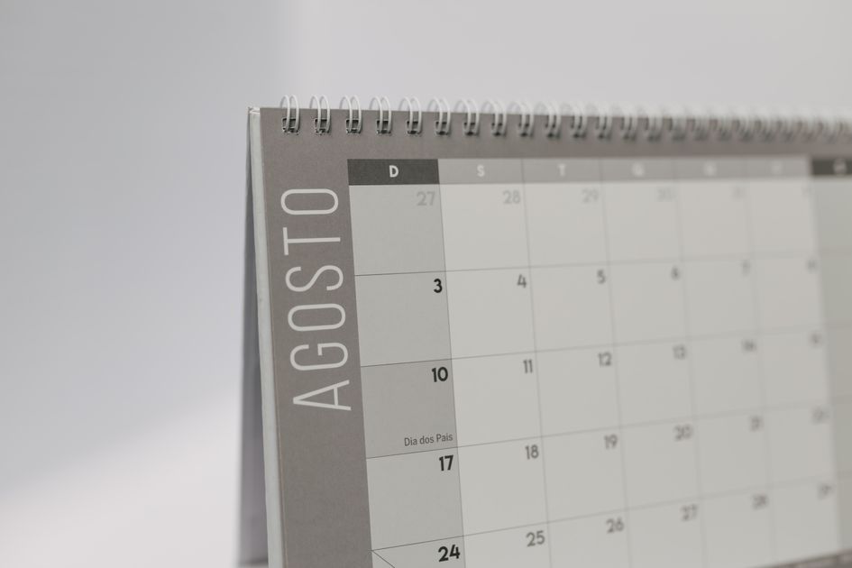 A woman marking important dates on her desk calendar