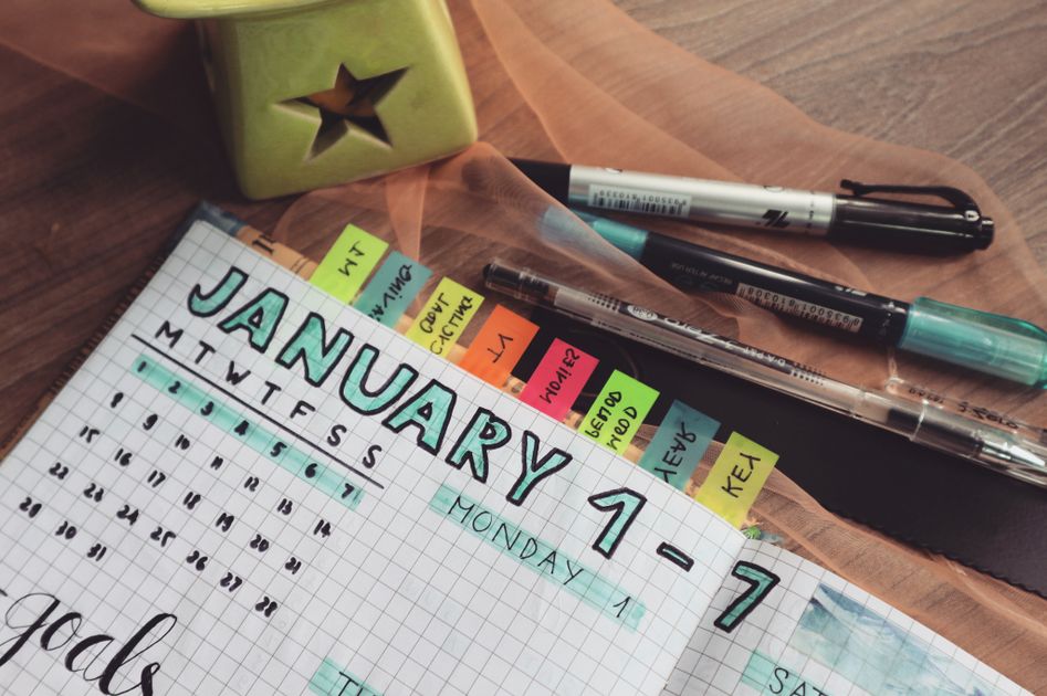 A person writing on a desk calendar in an office setting