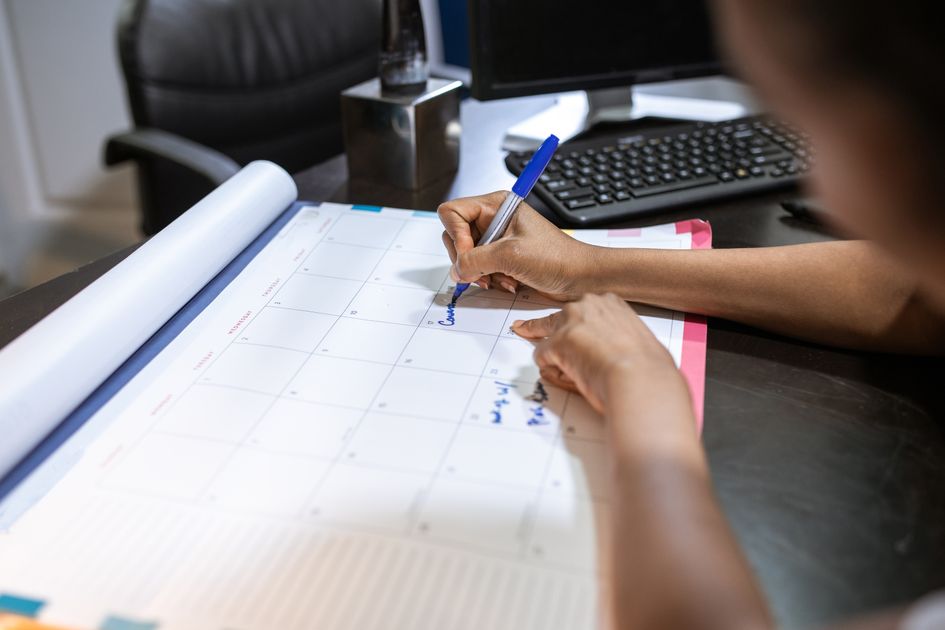 A detailed planner with goals and colorful tabs on a wooden desk