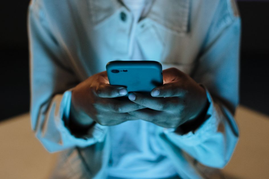 A person texting on a smartphone at night