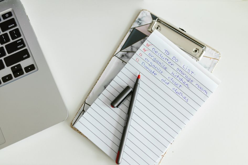 A neatly organized to-do list on a clipboard next to a laptop