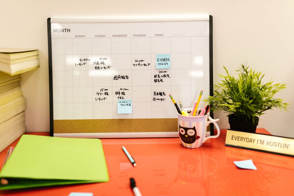 An organized desk with a calendar and notes for each client