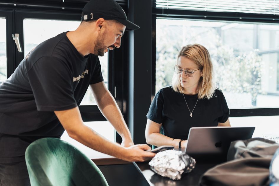 A man and woman collaborating in an office with a laptop