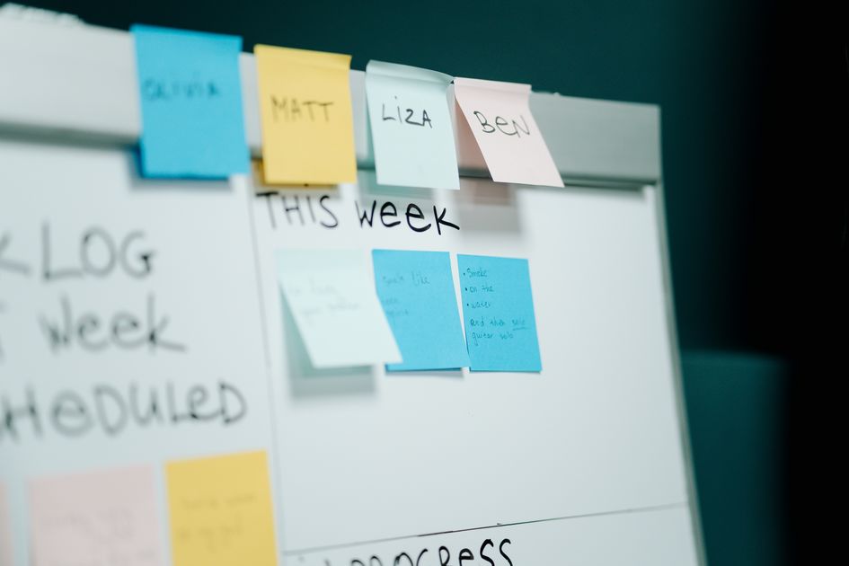 A close-up of colorful sticky notes on a whiteboard for task organization