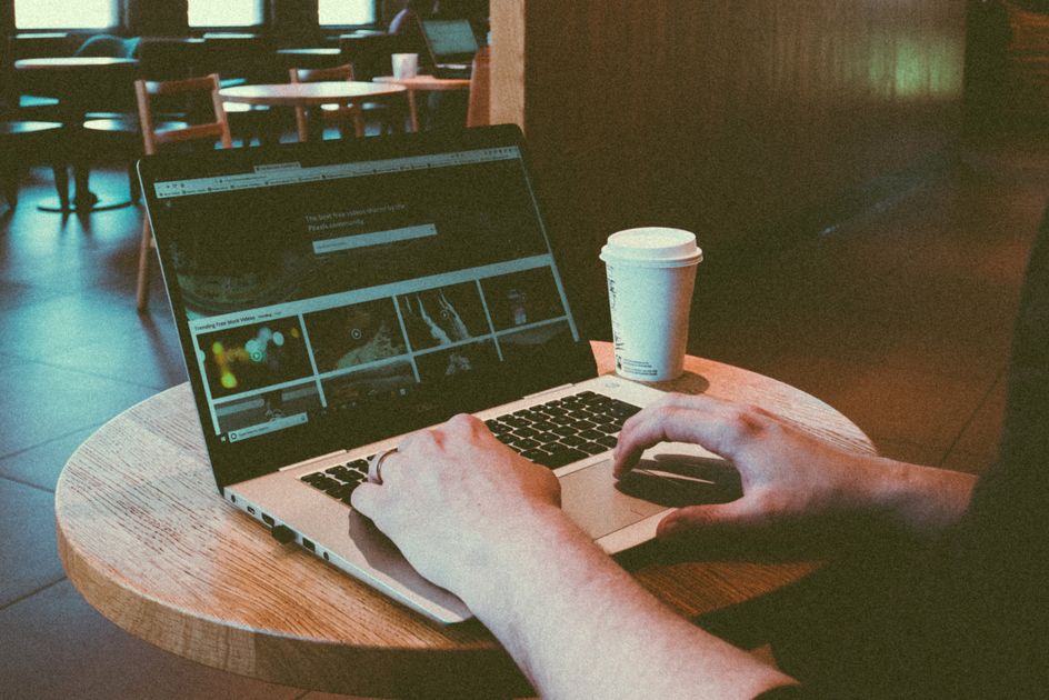A person using a laptop in a cozy cafe