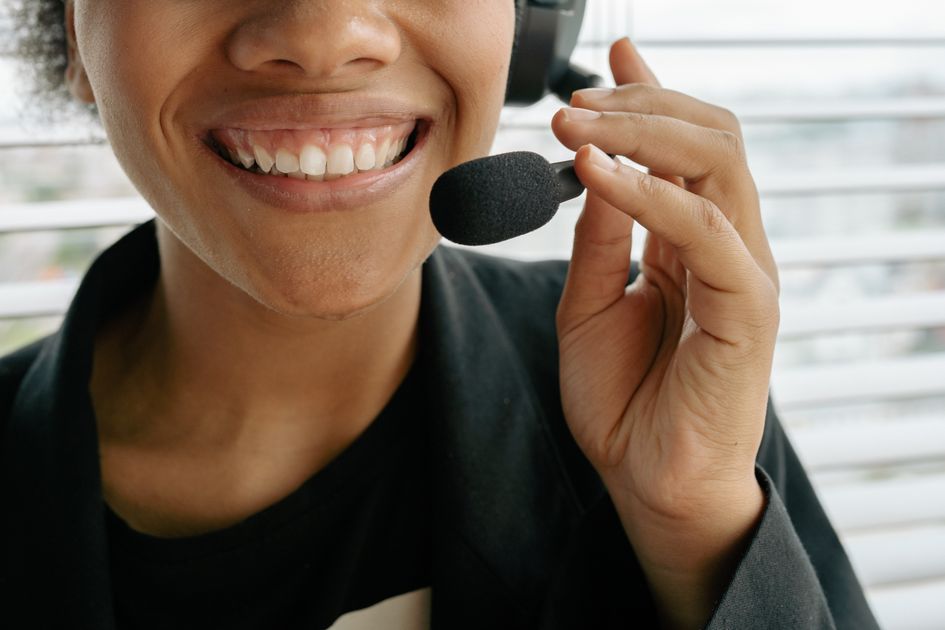 A smiling representative holding a headset microphone