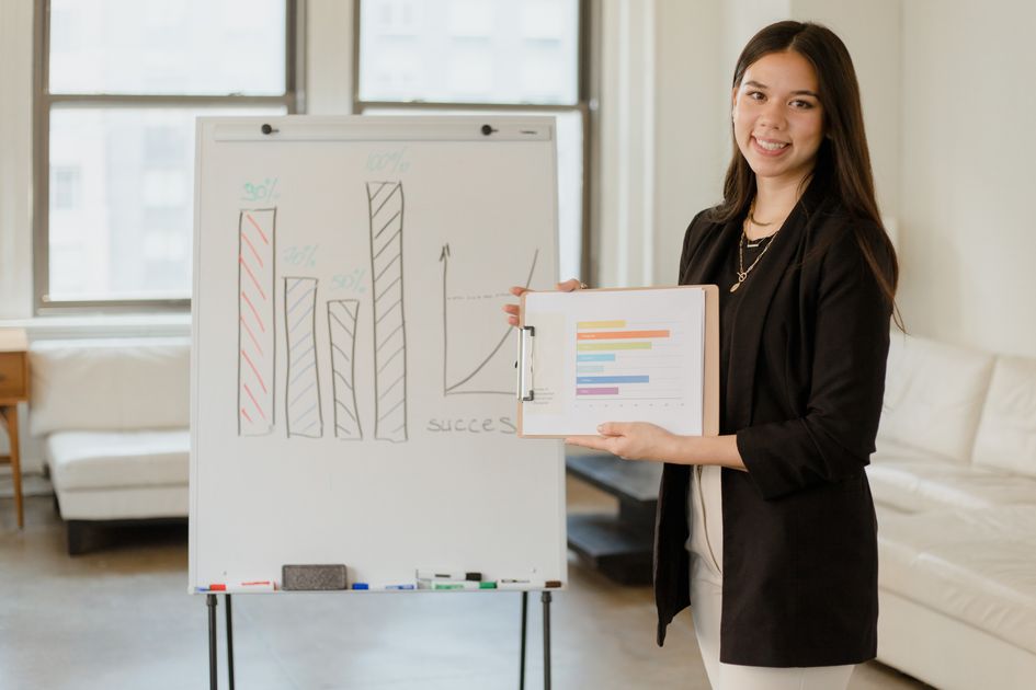 A woman presenting business data with a success graph in an office