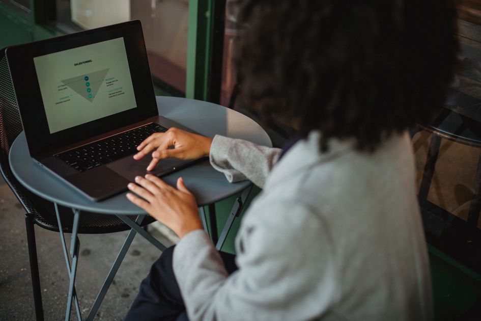 A woman working with a chart on a computer at an outdoor cafe