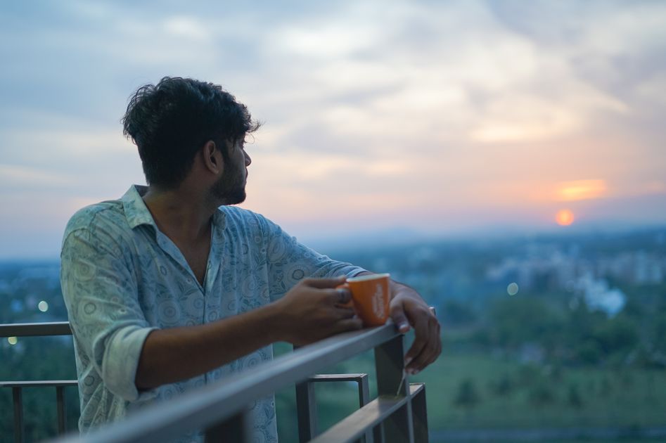 A person enjoying a peaceful sunrise with a cup of coffee