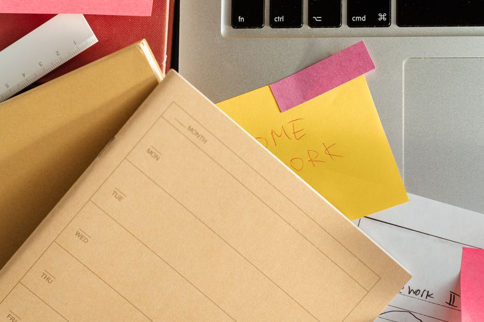 A laptop surrounded by color-coded sticky notes on a desk