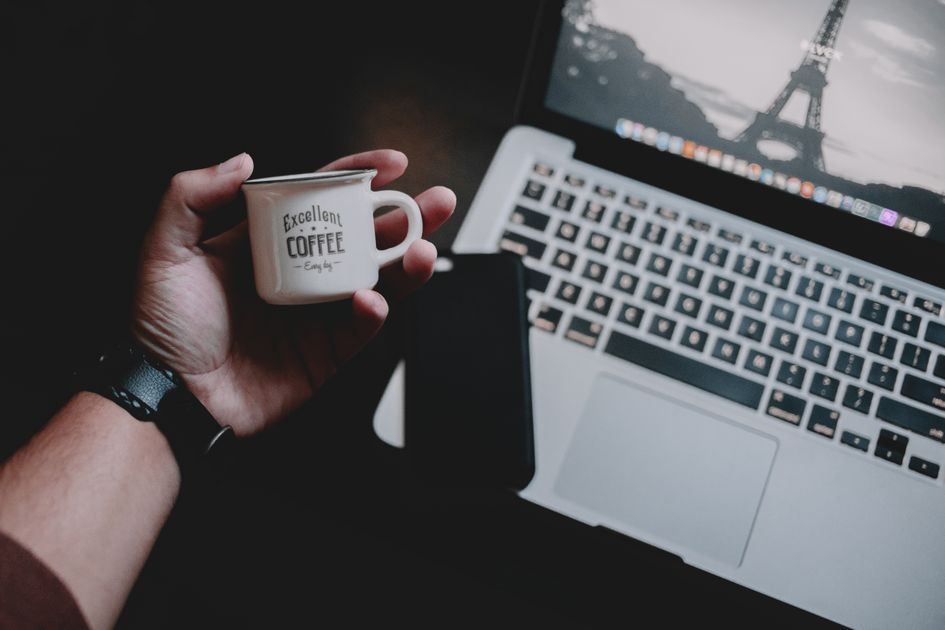 A cozy home office desk with a laptop and coffee cup