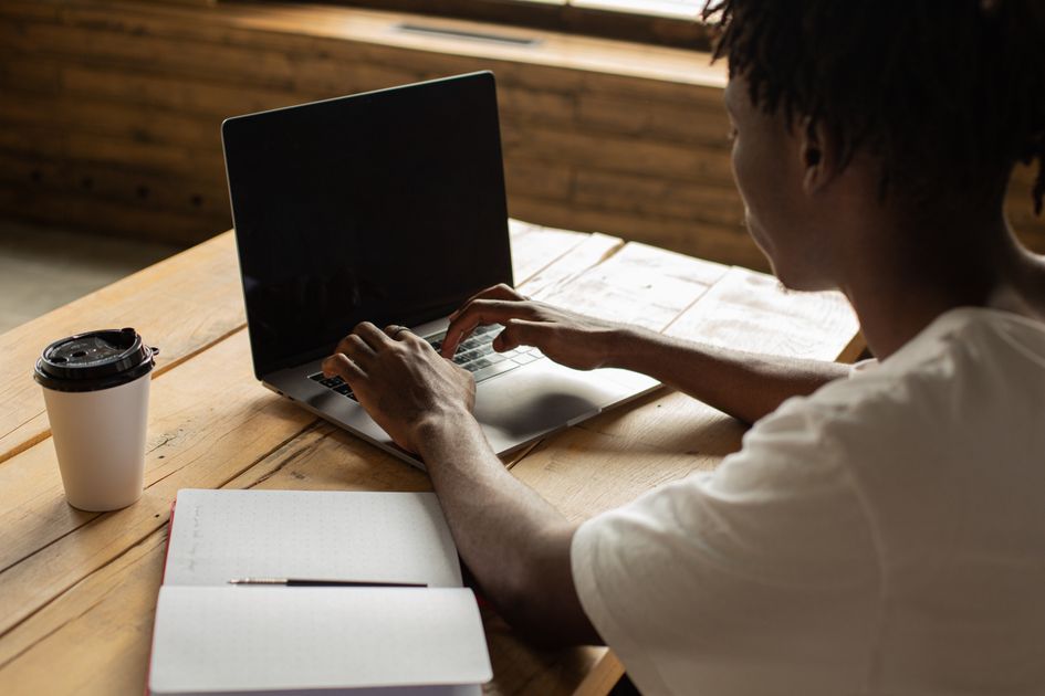 A young man working on a laptop in a cozy cafe