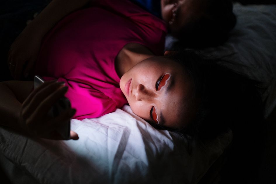 A woman using a smartphone in a dark room