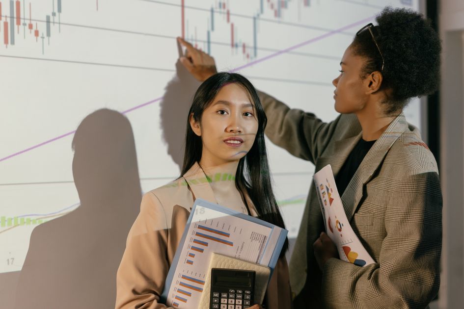 Two businesswomen analyzing financial projections