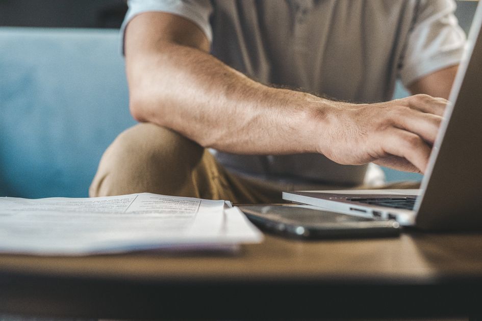 A man typing on a laptop at home