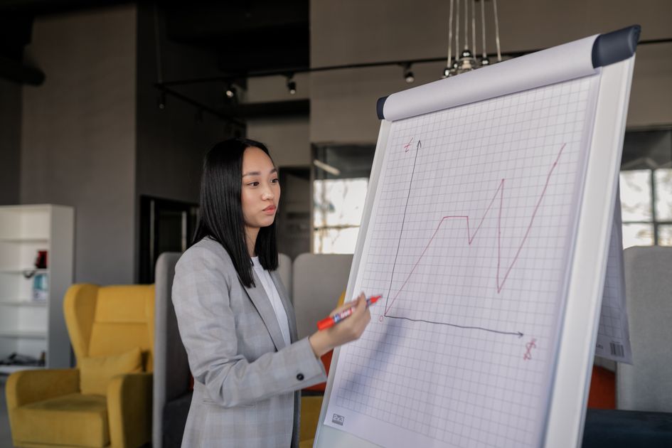 A businesswoman giving a presentation on a graph in an office