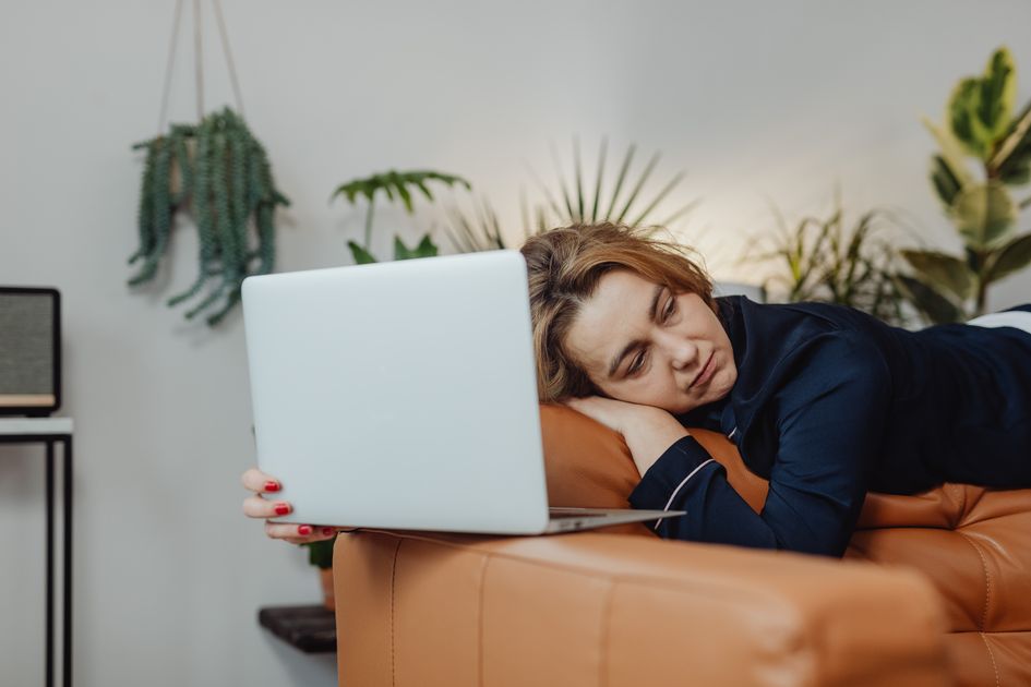 A person resting with a laptop after switching between tasks