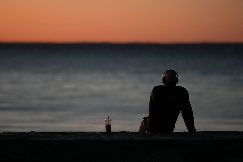 A person finding a calm moment by the water at dawn