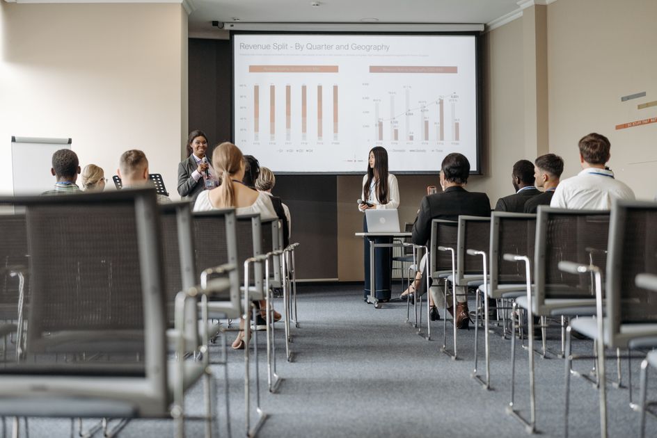 Business conference attendees listening to a revenue presentation