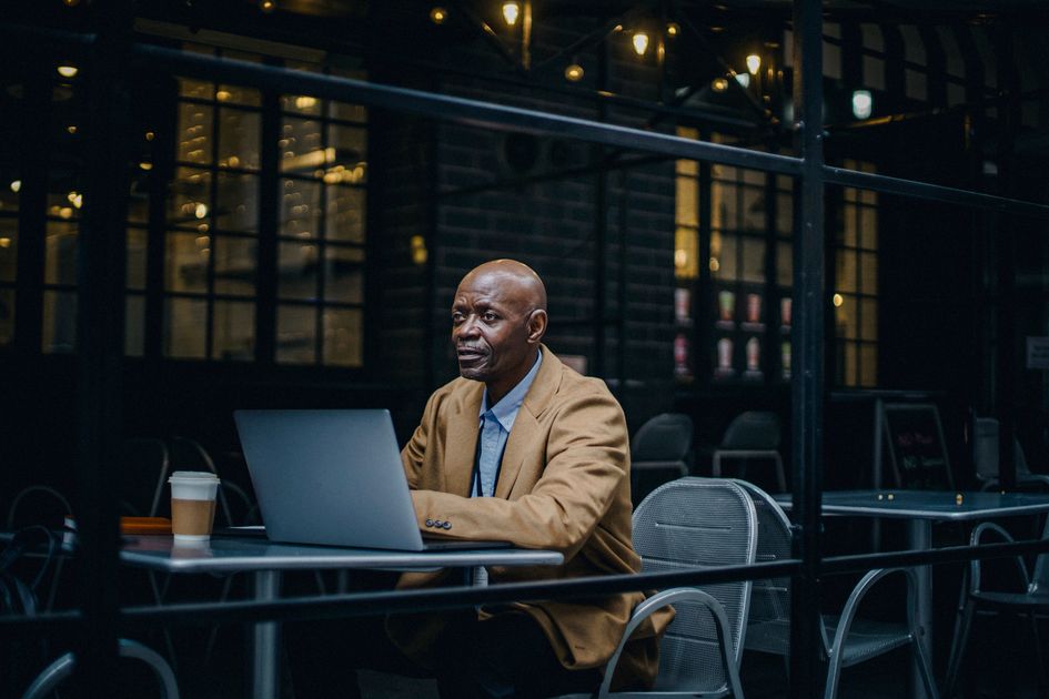 A man in a cafe working on a laptop while enjoying coffee