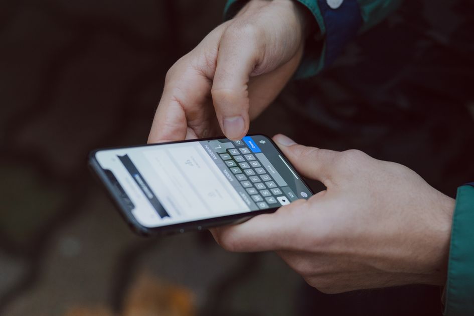 A close-up of someone scrolling through messages on a phone