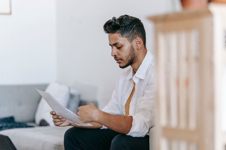 A man reading documents while sitting on a couch