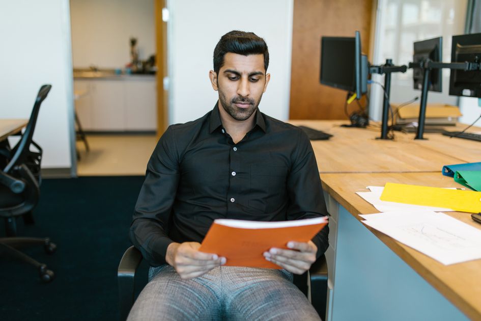 A businessman reviewing a document in a modern office