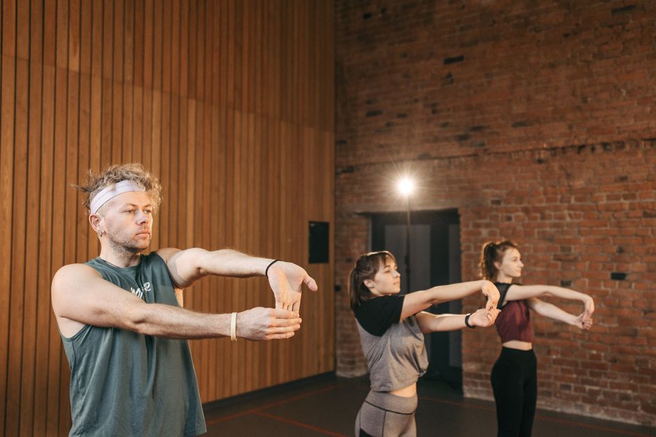 A group of gym members stretching together in a studio