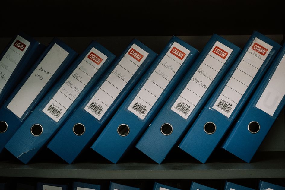 Neatly arranged blue office binders labeled for organized storage