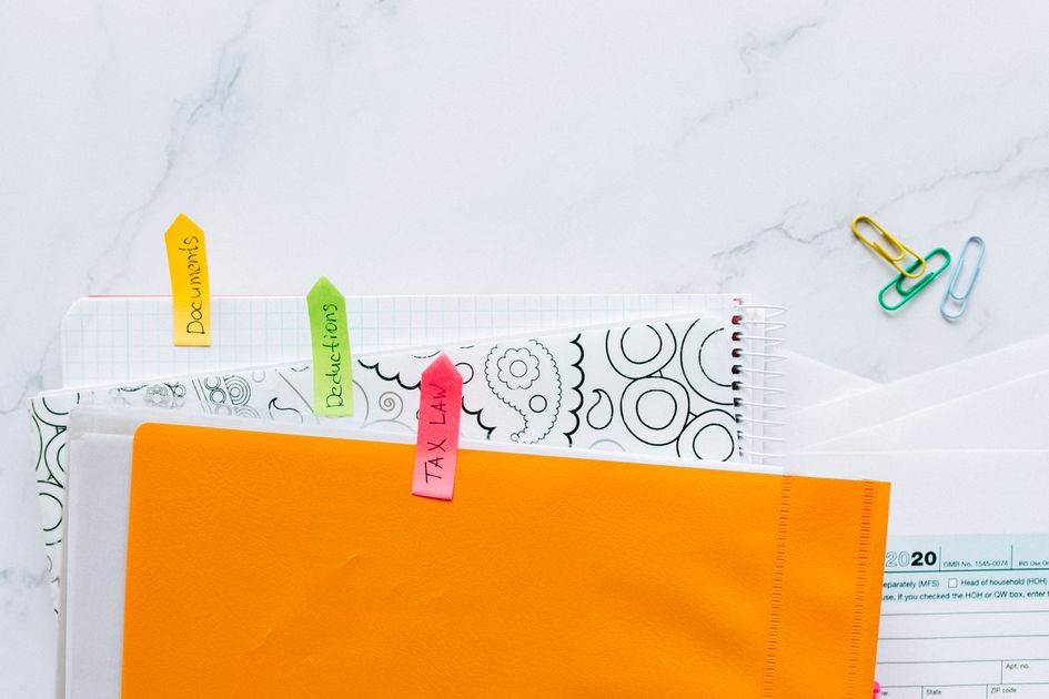 Documents organized with colorful sticky notes on a desk