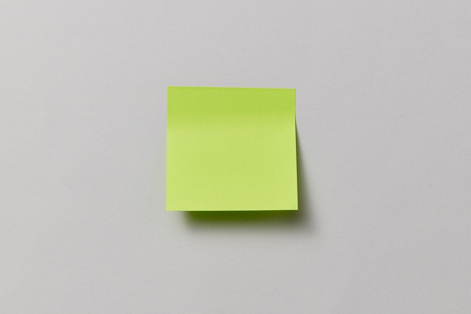 A single bright green sticky note on a neutral background