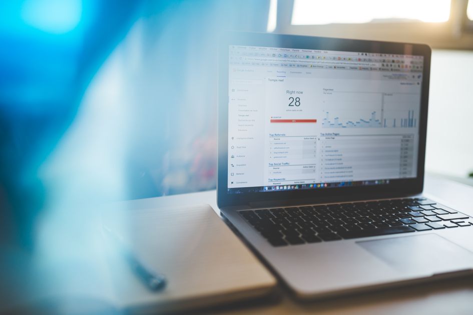 A laptop displaying an analytics dashboard in a workspace