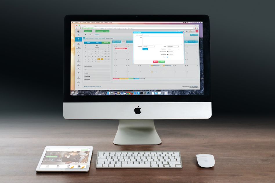 A desk setup featuring a desktop computer, tablet, and keyboard