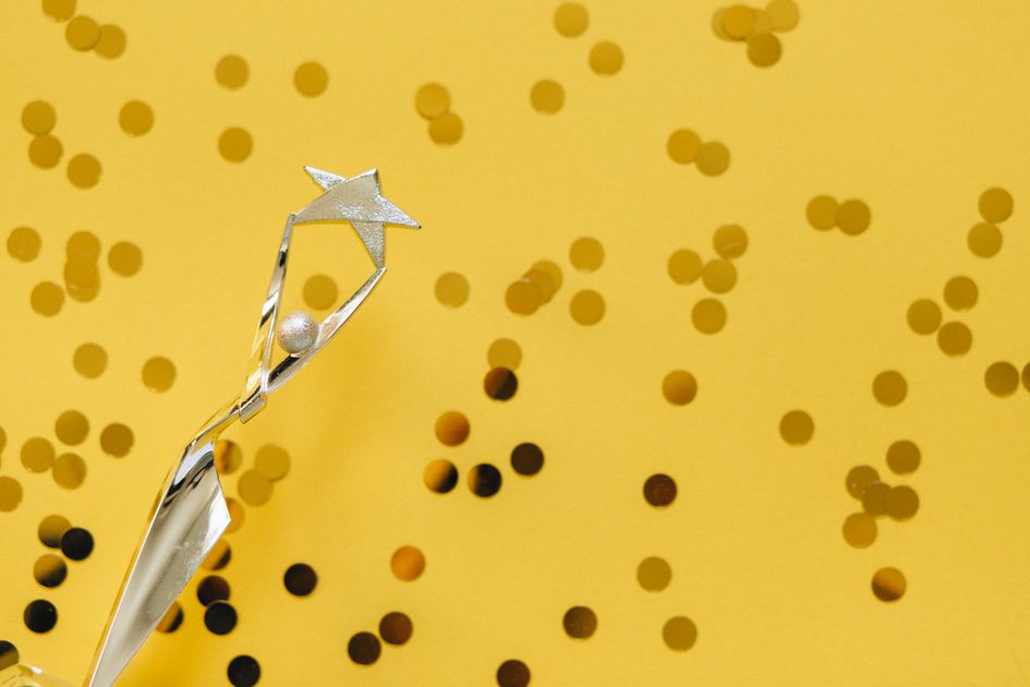 A silver trophy with a star design and confetti