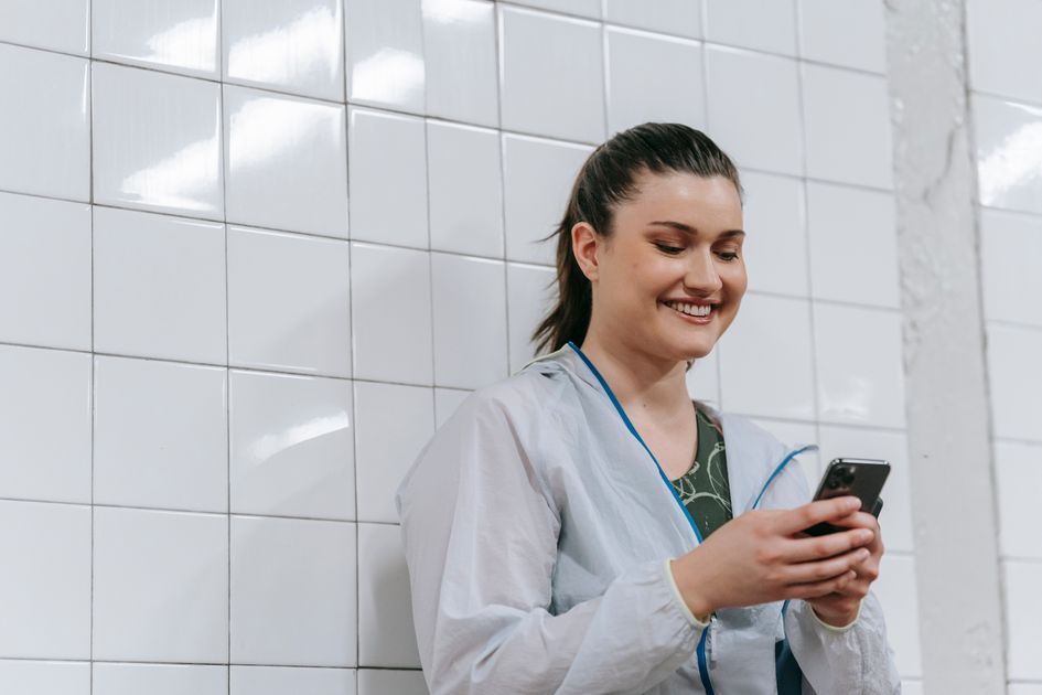 A woman happily texting on her smartphone