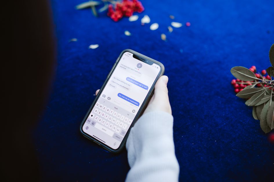 A person holding a smartphone displaying text messages